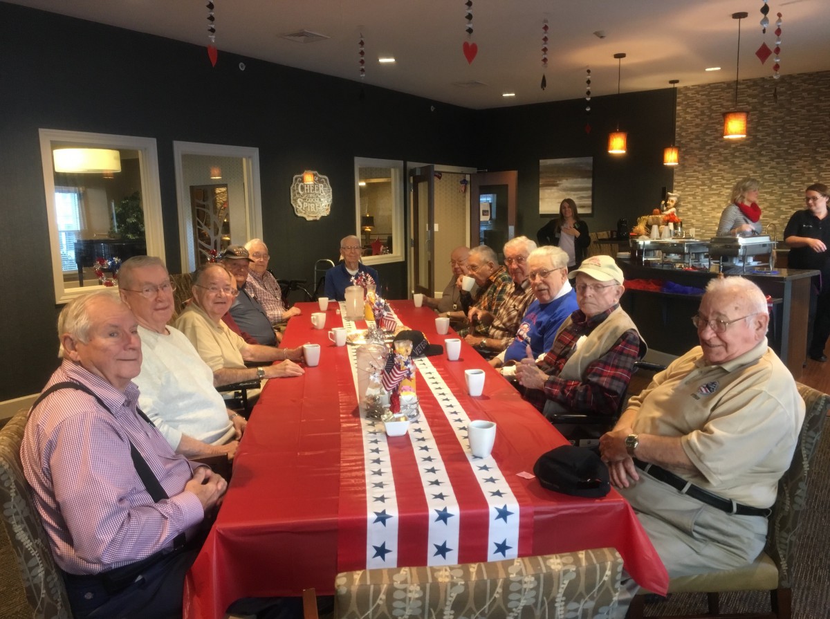 A group of people gathered around a table indoors for a meeting.