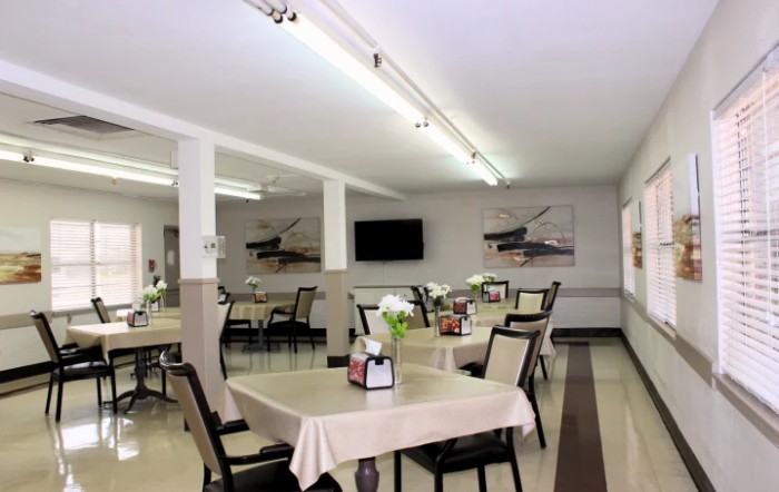 A clean and well-lit dining area with neatly arranged tables and chairs.