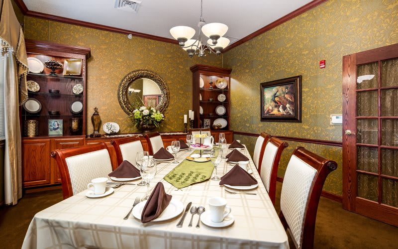 Elegantly set dining room with a chandelier and decorative accents.
