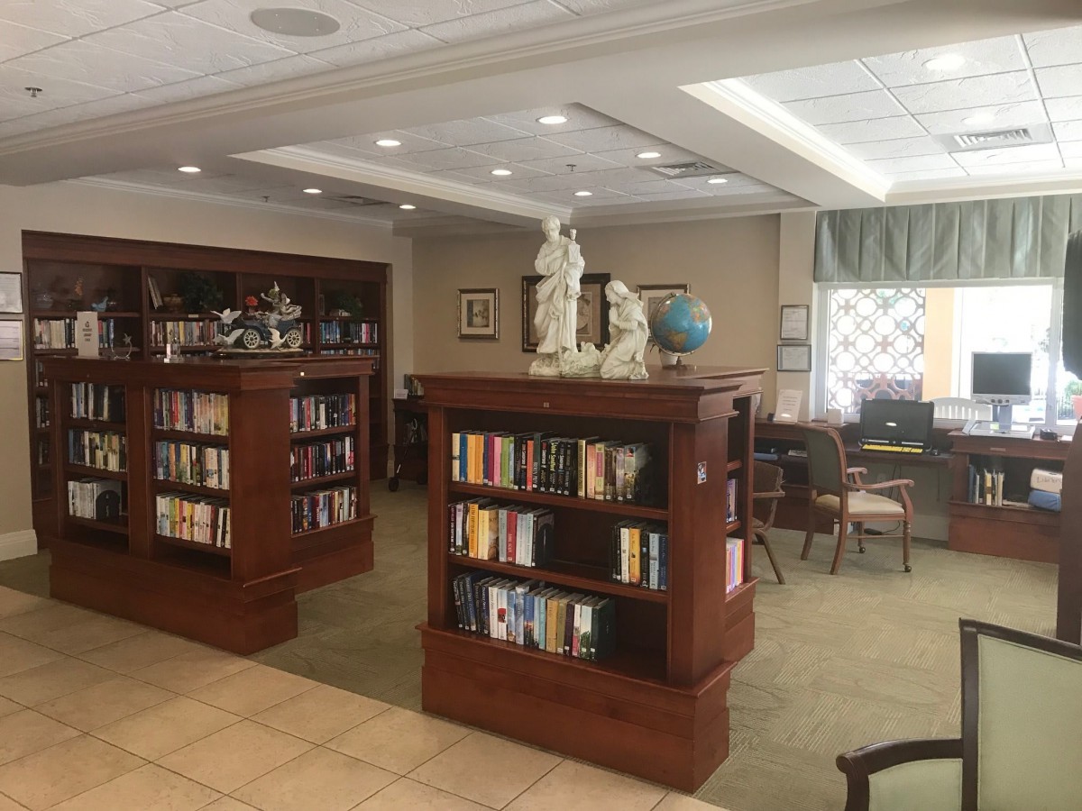 A cozy library interior with bookshelves, sculptures, and a reading area.