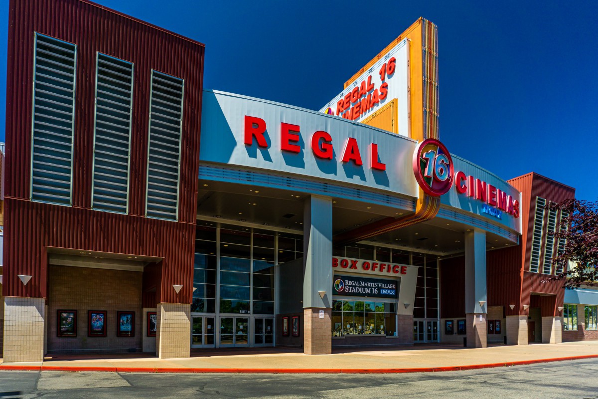 The entrance of a Regal Cinemas movie theater on a sunny day.