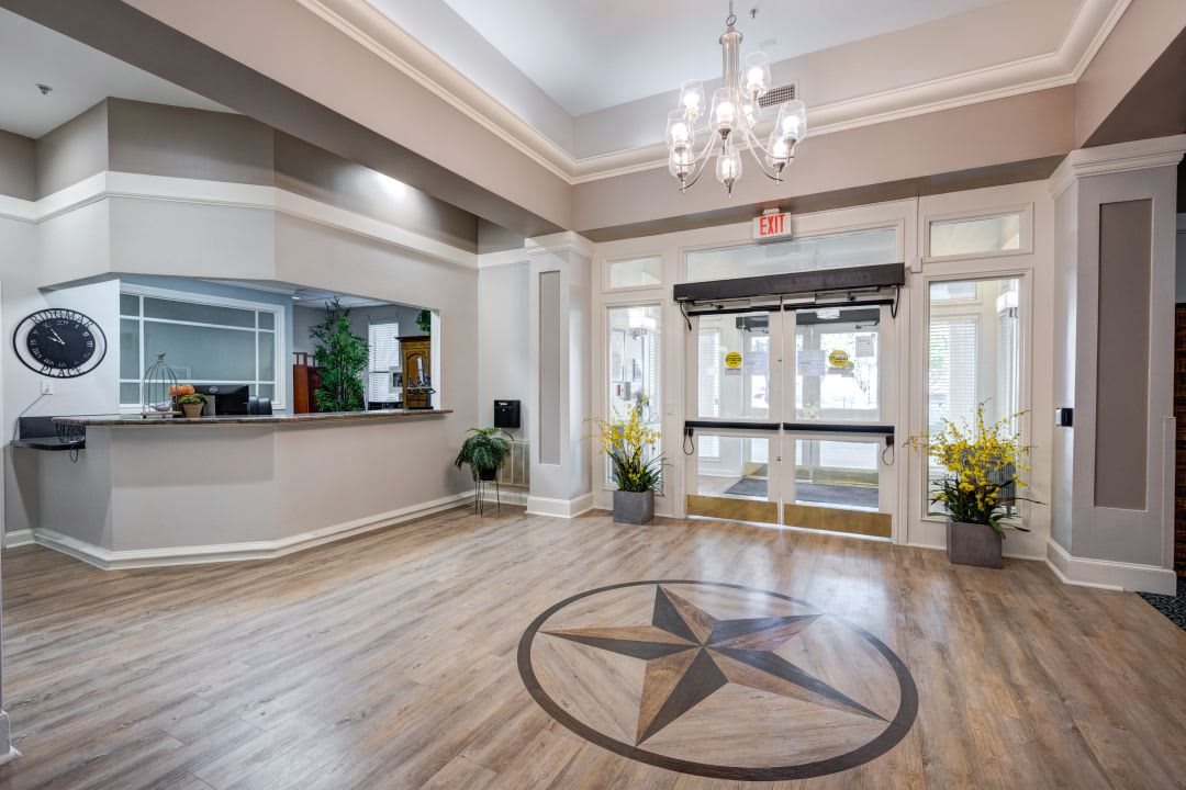 A welcoming hotel lobby with a chandelier and stylish floor design.
