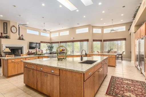 A bright and spacious modern kitchen featuring wooden cabinets and elegant granite countertops.