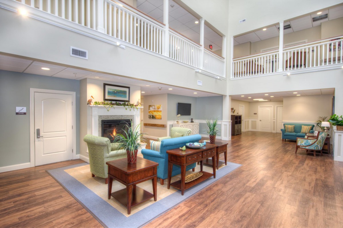 A spacious and elegant living room with a fireplace, high ceilings, and comfortable seating.
