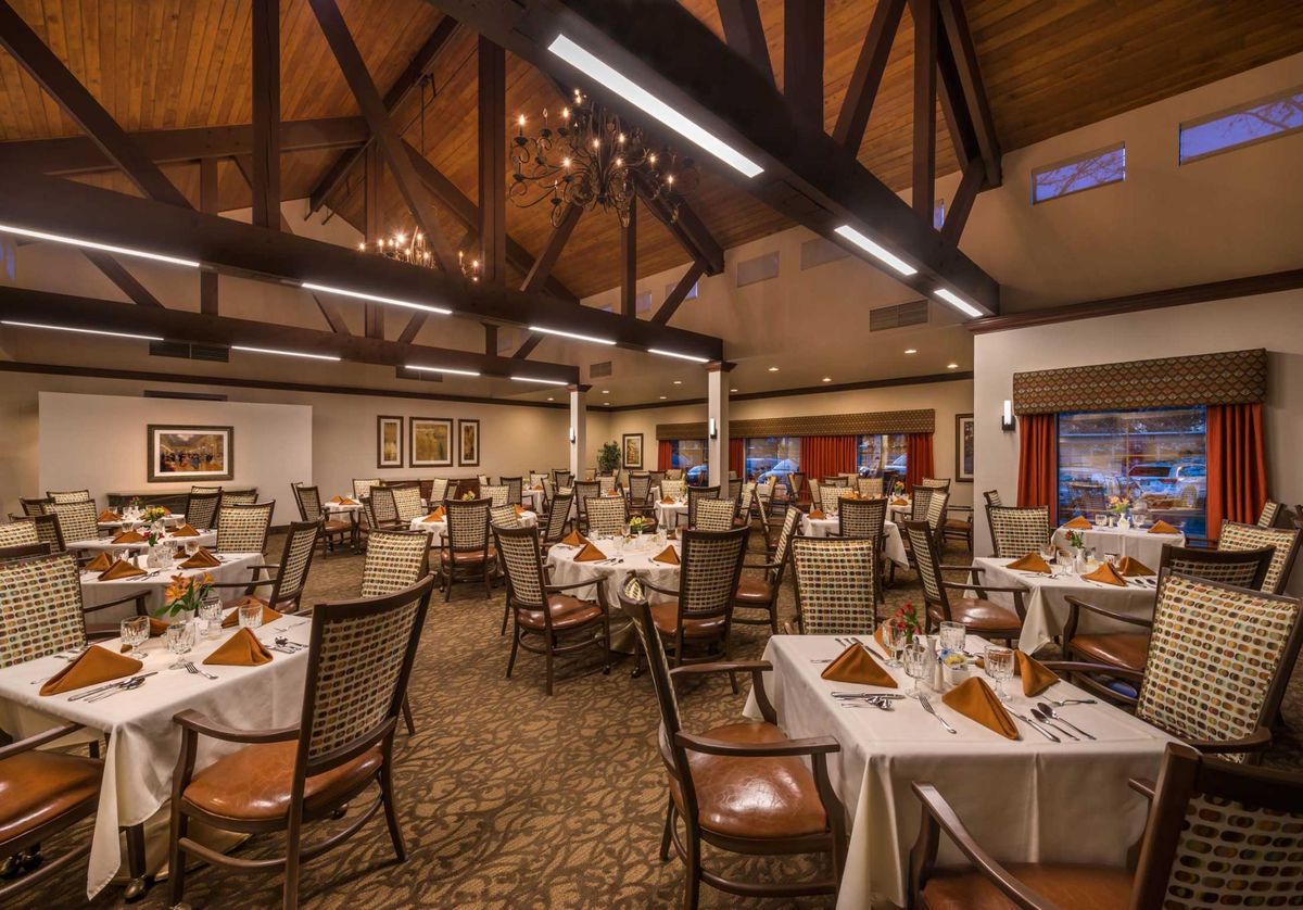 An elegant restaurant dining area with neatly arranged tables and ambient lighting.
