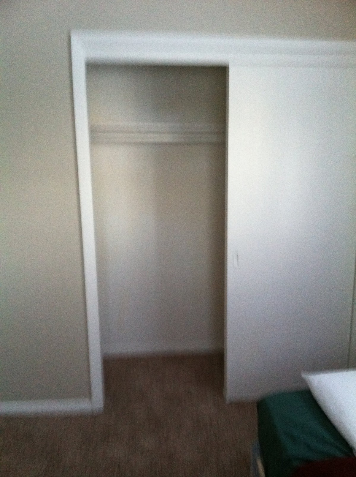 An empty closet with a sliding door in a minimalist interior.