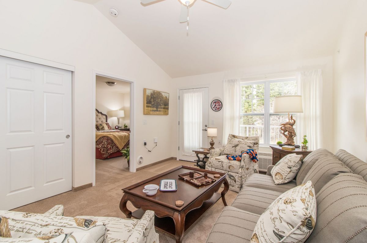 A cozy living room with a sofa set, coffee table, and decorative items in a bright and well-lit space.