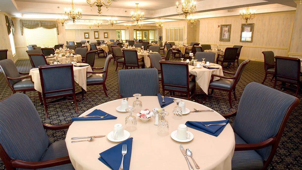 Elegantly set dining room with neatly arranged tables and classic decor.