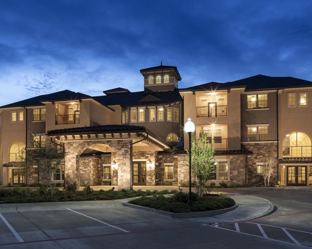 A beautifully lit building at dusk with well-maintained landscaping.
