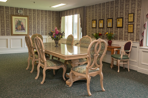 A beautifully arranged dining room with an elegant table and chairs, complemented by floral decor and patterned wallpaper.