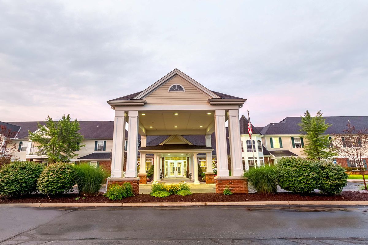 Grand entrance of a hotel with classic columns and well-maintained landscaping.