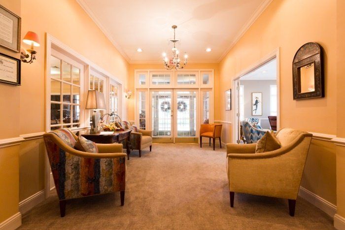 A bright and elegantly decorated living room with sofas and a chandelier.