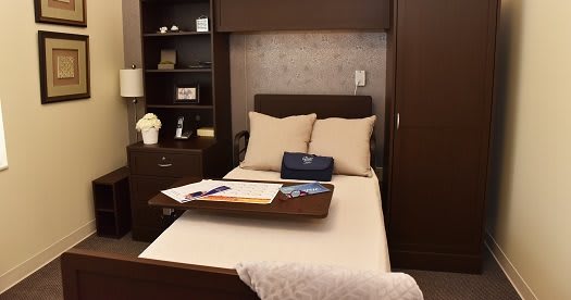 Cozy bedroom setup with a neatly arranged bed, pillows, and a wooden tray.