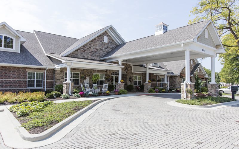 A residential building with a stone facade and a covered entrance.