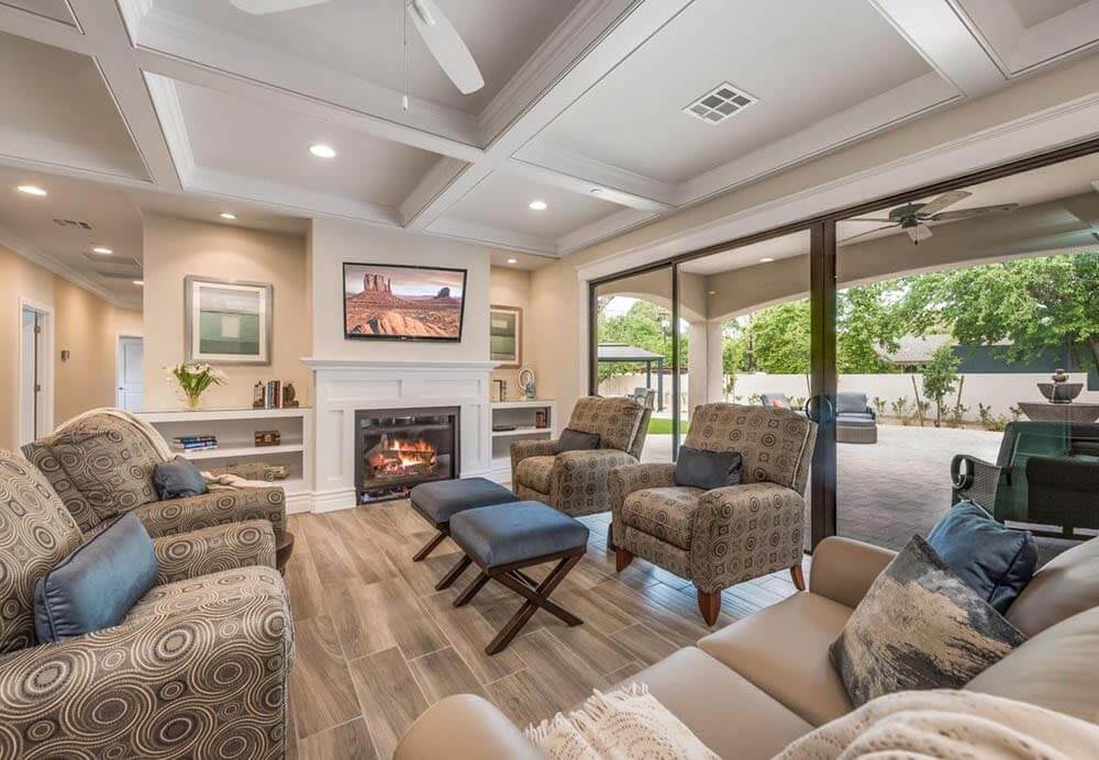 A modern living room with a cozy fireplace, ample seating, and natural light streaming through sliding glass doors.