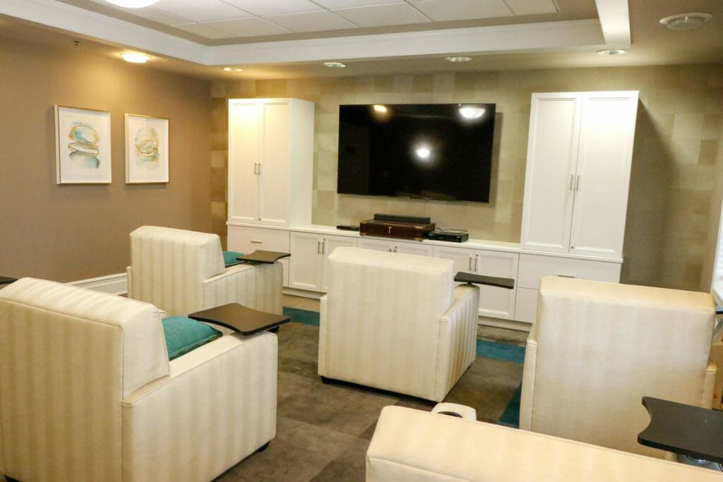 A modern lounge area with comfortable armchairs and a large TV.