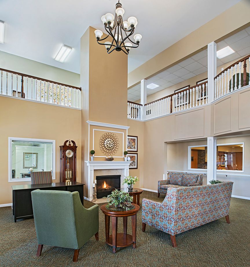 A spacious lobby with comfortable seating, a fireplace, and a chandelier.