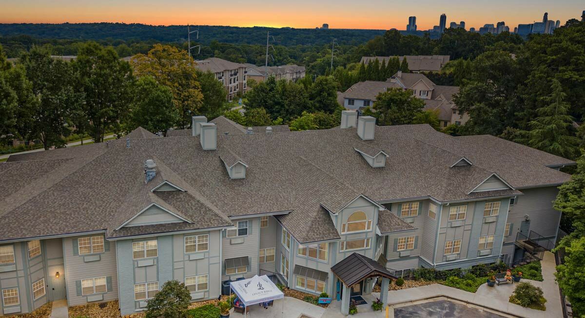 A suburban residential building at sunset with a view of the surrounding landscape.