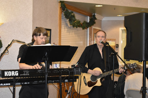 Two musicians performing live, one playing guitar and the other on keyboard.