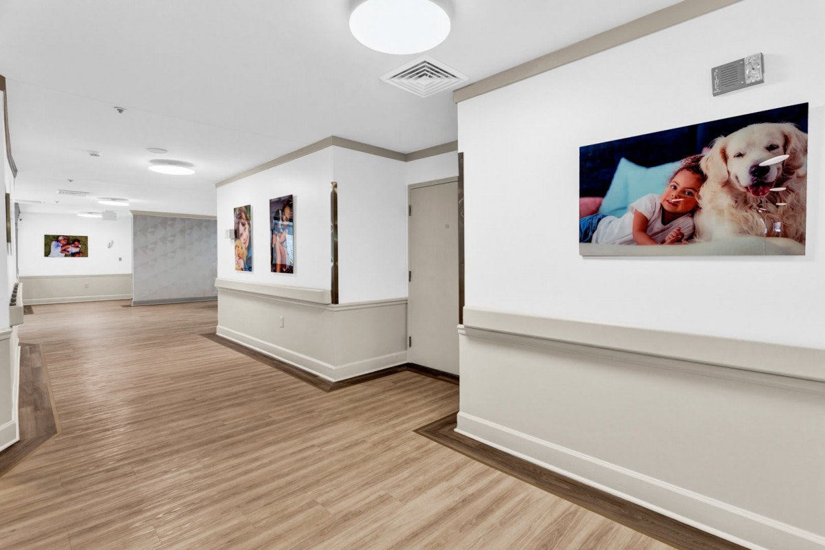 A hospital hallway decorated with baby photos on the walls, featuring clean and modern interior design.