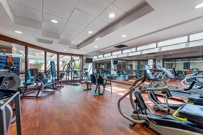 A spacious gym with various exercise equipment and cardio machines.