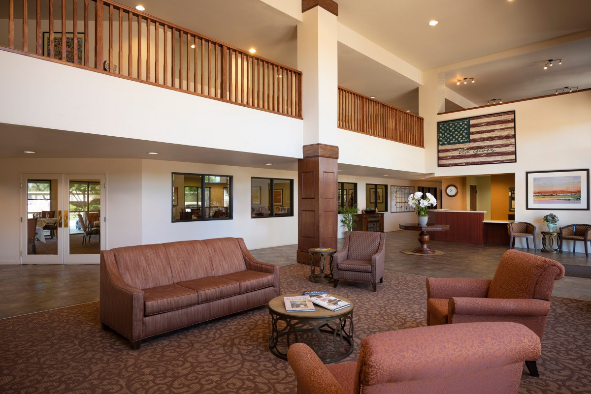 A spacious hotel lobby with comfortable seating and a reception desk.