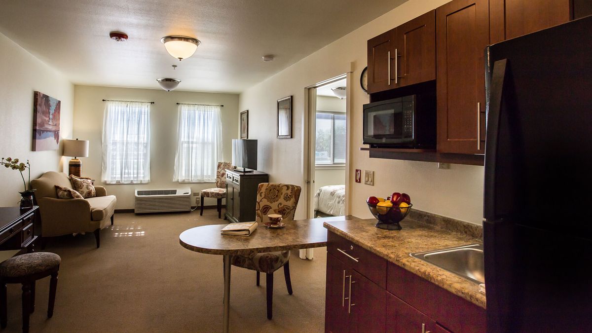 A cozy living area featuring a kitchenette with modern appliances and a comfortable seating arrangement.