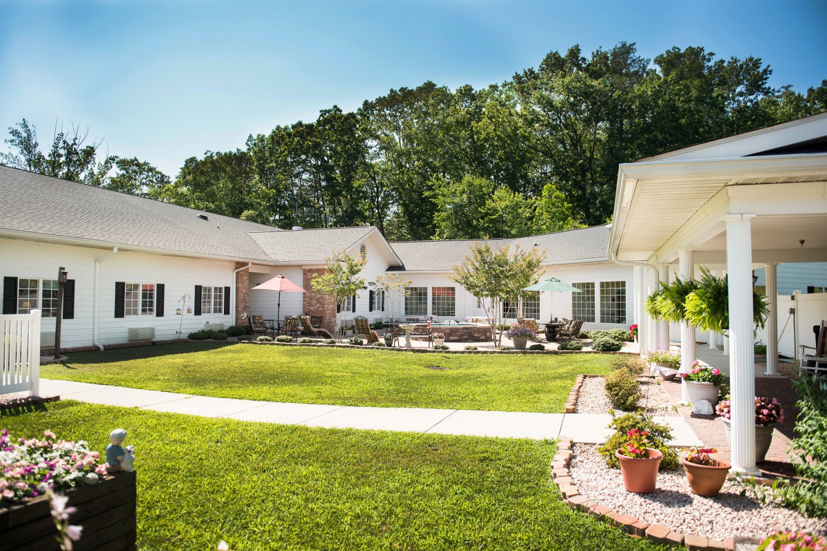A peaceful courtyard with a well-maintained lawn surrounded by buildings and trees.