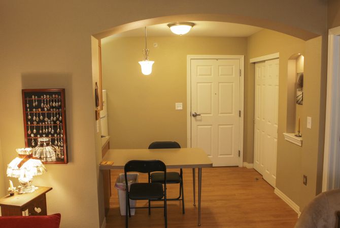A small dining area with a table and two chairs under warm lighting.