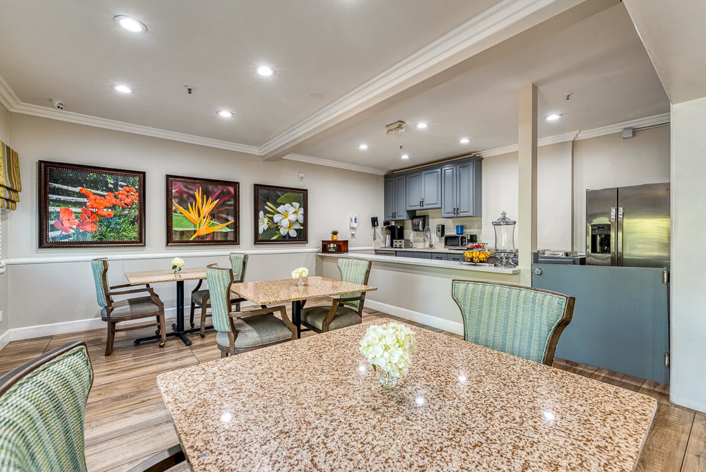 A well-lit dining area featuring elegant tables, chairs, and vibrant artwork on the walls.