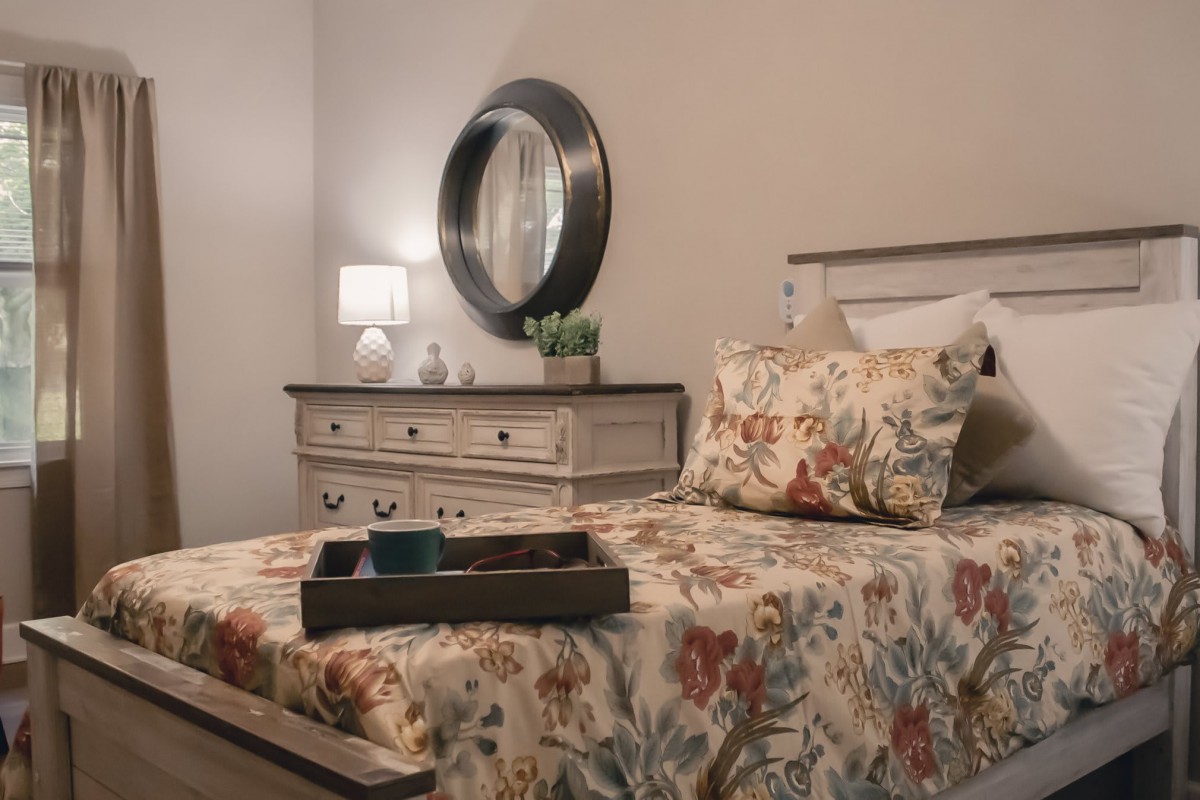 A cozy bedroom with floral bedding and elegant decor.