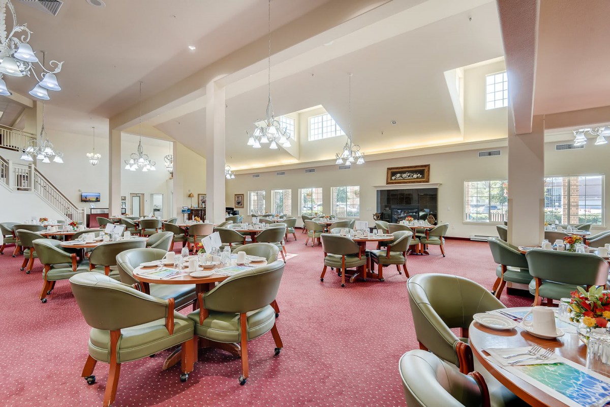 A spacious and elegantly decorated dining area with neatly arranged tables and chairs.