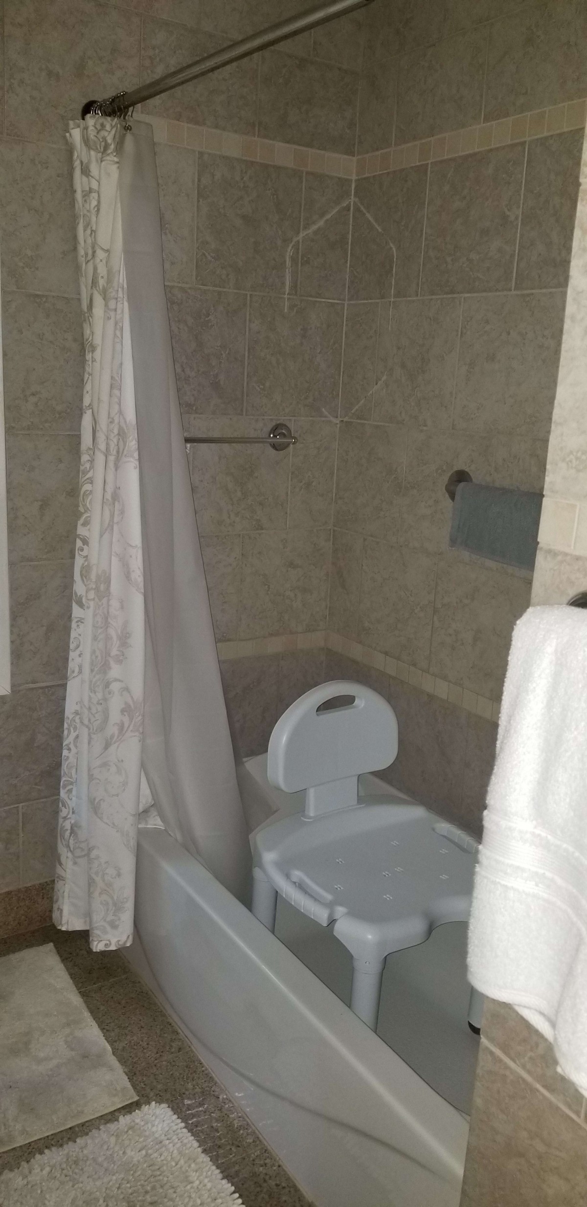 A bathroom featuring a toilet, shower curtain, and tiled walls.