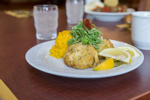 Delicious crab cakes served with a fresh garnish and lemon slices.