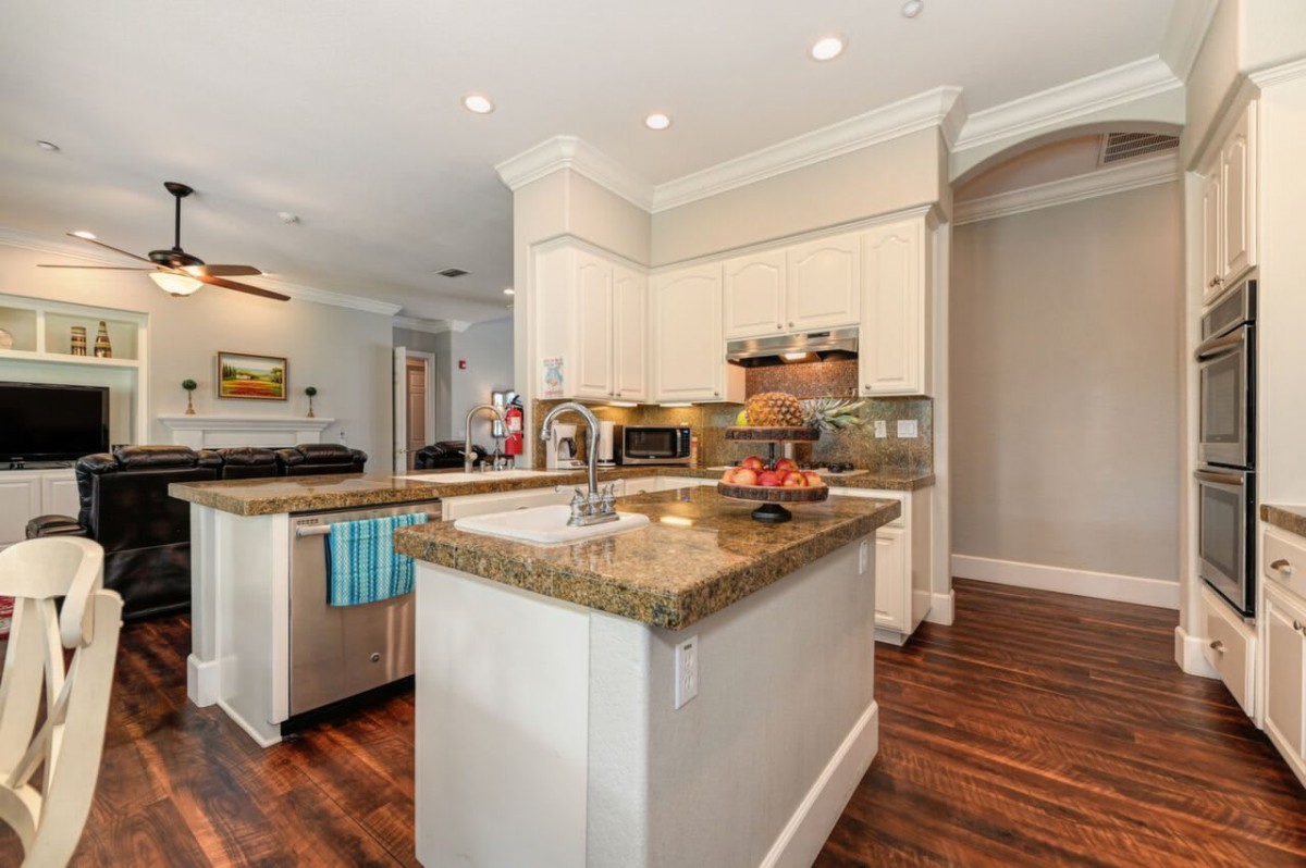 A modern kitchen featuring a central island and wood flooring.
