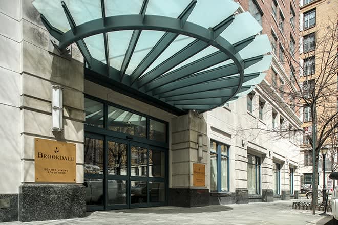 The entrance of a modern building featuring a distinctive glass canopy.