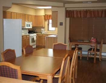 A cozy dining area adjacent to a kitchen with wooden furniture and cabinetry.