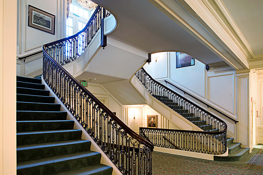 An elegant interior staircase with a decorative balustrade in a hotel.