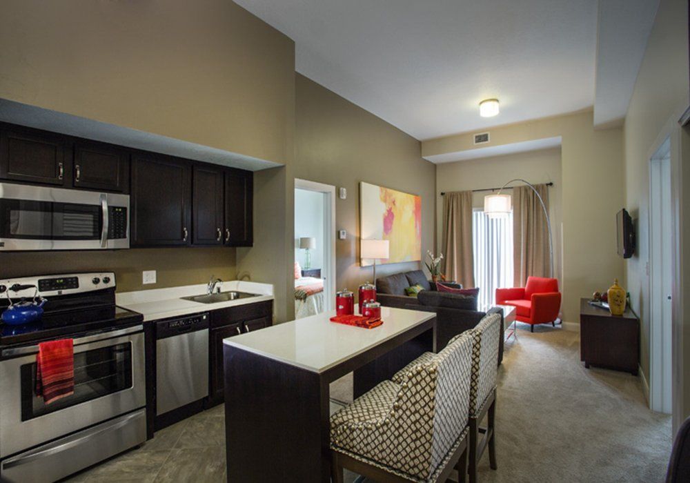 A modern open-concept kitchen and living room with an island counter and stylish furniture.