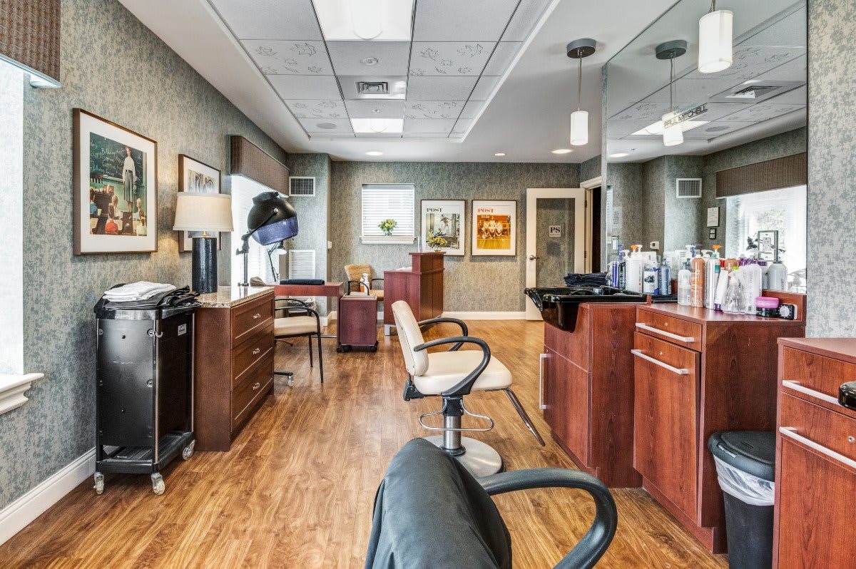 A modern hair salon with styling stations, mirrors, and comfortable chairs.