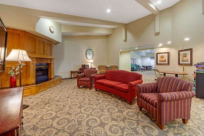 A cozy lobby with red and striped seating, decorative carpet, and a warm ambiance.