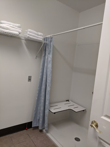 A minimalist bathroom shower area with neatly arranged towels and a simple curtain.