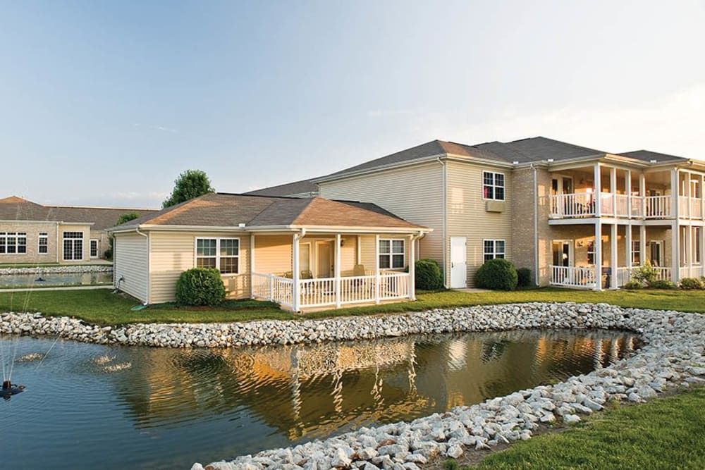 A residential apartment building with a small pond in the foreground.