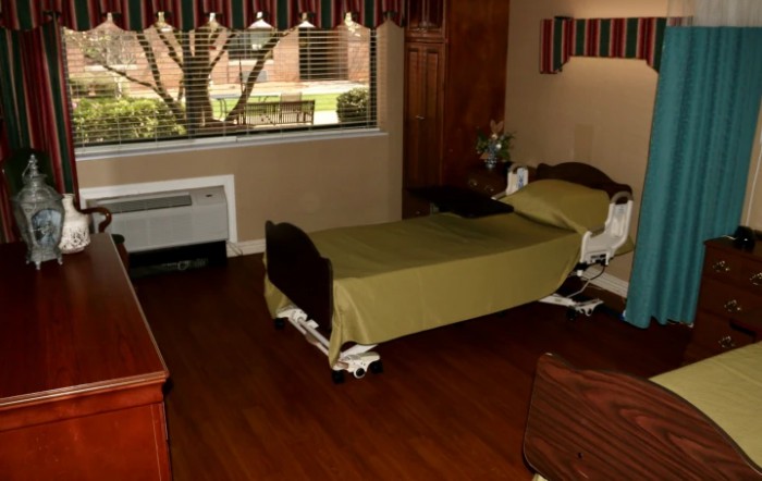 A room with a single hospital bed and a window.