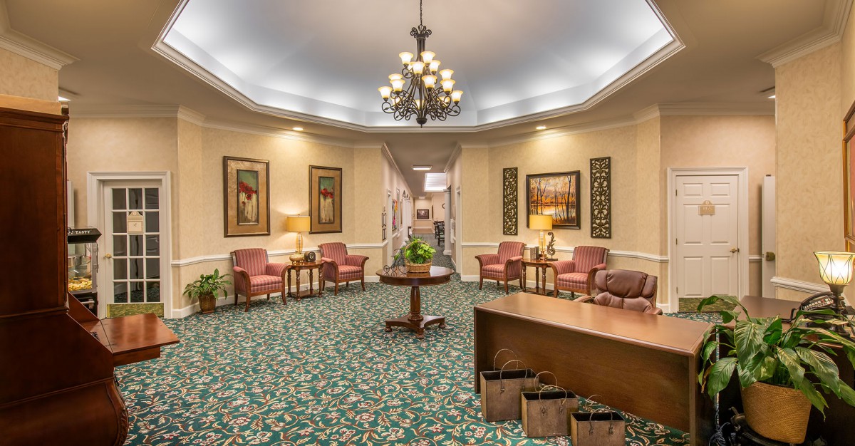 A warmly lit lobby area with a chandelier, seating arrangements, and decorative elements.