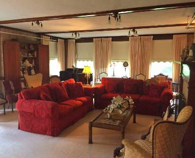 A cozy living room featuring plush red sofas and ample natural light.