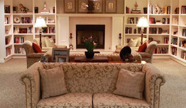 Cozy living room with a central fireplace, plush sofa, and elegant decor.