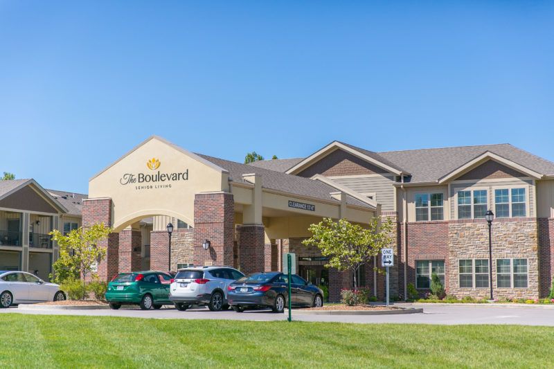 A hotel building with a parking lot on a clear, sunny day.