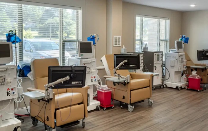A clinic room equipped with dialysis machines and comfortable chairs for patient treatment.