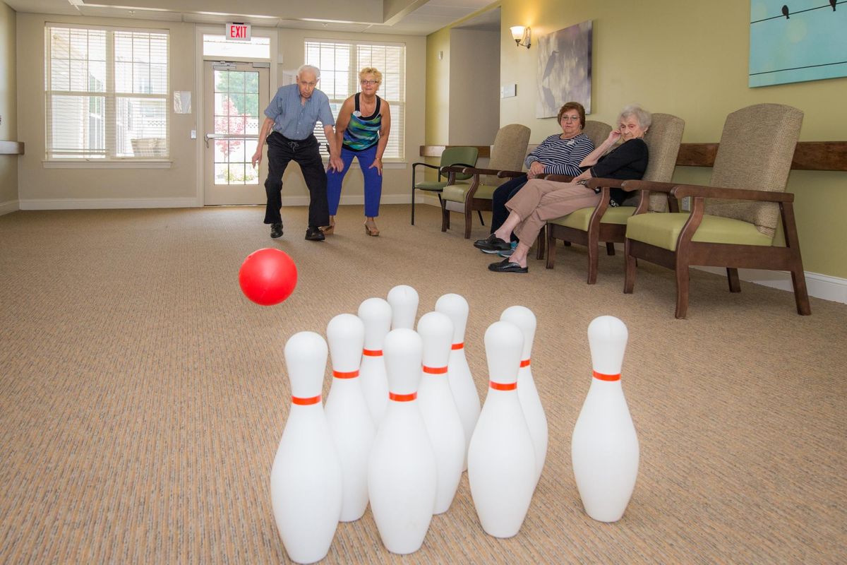 Seniors enjoying an indoor bowling game in a community setting.